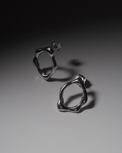 Handcrafted abstract molten silver stud earrings. Made from sustainable recycled silver. Handmade jewellery London jewellery brand Nowhere Soon Studio.