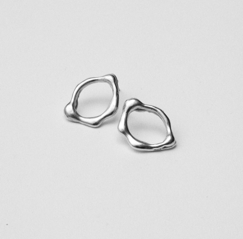 Handcrafted abstract molten silver stud earrings. Made from sustainable recycled silver. Handmade jewellery London jewellery brand Nowhere Soon Studio.